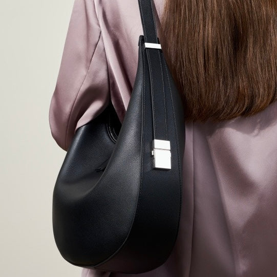 Minimalistisk designad äkta läderväska med halvmåneformad axelrem