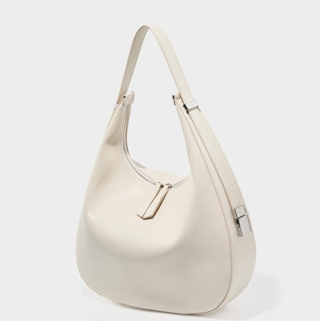 Minimalistisk designad äkta läderväska med halvmåneformad axelrem