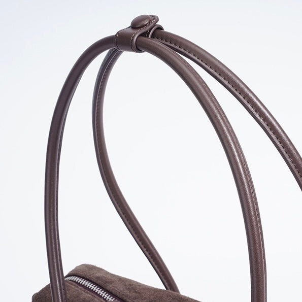 Matt axelväska med tofshänge i äkta läder
