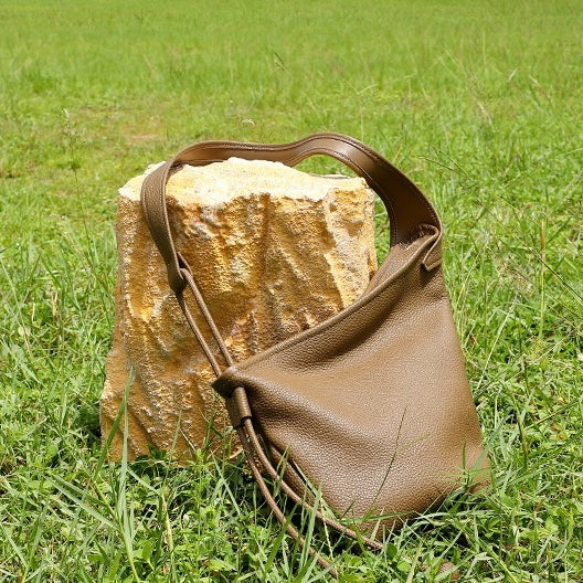 Minimalistisk asymmetrisk design med lös hornformad axelremsväska